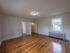 large bedroom with lots of windows, hardwood floor, overhead light, radiator