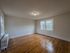 large bedroom with lots of windows, hardwood floor, overhead light, radiator