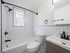 renovated bathroom, white tile walls, vanity sink, energy efficient toilet, window, modern accents