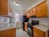 kitchen with wooden cabinets and black fridge and oven/stove, apartment kitchen, lots of cabinets