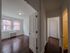 view down hallway of apartment and into one of the bedrooms, hardwood floor throughout, overhead lights, newly renovated