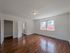 hardwood floor bedroom with large windows, overhead light, and spacious closet, view towards hallway