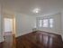 spacious living room with large windows, hardwood floors, radiator heat, overhead light