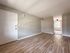 renovated living room, wood panel floor, closet, doorway leading to kitchen with ceiling fan