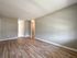 renovated living room, wood panel floor, closet, doorways leading to kitchen and hall