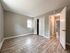 bedroom with wood panel floors, door leading to hallway, window, long closet with sliding doors