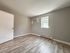 bedroom with window, air conditioner, baseboard heating, wood floor