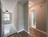 view into hallway and kitchen, wood floor, tile floors, overhead light, ceiling fan, big window
