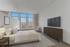 Bright furnished bedroom at Franklin Manor Apartments in West Reading, PA with queen bed, nightstands, and large windows.