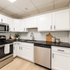 Kitchen at Franklin Manor Apartments with white cabinets, black counters and stainless appliances.