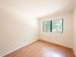 Bright, airy room with large window, showcasing natural light and elegant wood flooring.