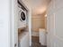 Bright and functional apartment corner featuring an in-unit washer and dryer next to a modern bathroom with sleek fixtures.