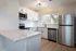 Spacious kitchen with granite countertops, peninsula kitchen islands, Stainless Steel Appliances, window above the sink and overhead lighting.