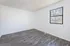 Spacious bedroom with vinyl wood flooring and large windows.