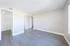 Spacious bedroom with vinyl wood flooring and large windows.