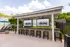 Resort-Style Pool and Tiki Bar with barstool seating, large flat screen tvs, and overhead string lighting.