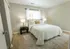Large master bedroom with window behind the bed, hardwood flooring, and spacious closet space for extra storage.