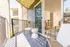Spacious balcony with large sliding door and patio furniture.