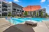 A sparkling outdoor swimming pool surrounded by lounge chairs and umbrellas, located at The Ave in Clintonville, Ohio. Apartments in Columbus with pool.