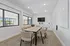 Spacious conference room with stylish desks, comfortable seating, a large white board, and windows for natural light.