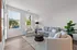 A living room with ample space for seating, featuring comfortable furniture, large windows that let in natural light, and an open layout.