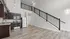 Loft apartments in Columbus, OH at The Ave. with large lofted bedroom, staircase with matte black railing and dark wood kitchen cabinetry.