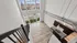 Loft style apartment overlooking the downstairs from the lofted bedroom with floor to ceiling windows and dark wood kitchen cabinetry.