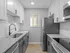 Sleek and modern kitchen featuring granite countertops, stainless steel appliances, and white cabinetry.