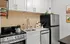 Stylish kitchen featuring modern appliances, sleek white cabinets, and a gold-tone faucet.