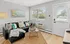 Bright and inviting living room featuring a modern black sofa with colorful throw pillows, a chic coffee table, and a large window with natural light.