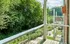 Balcony overlooking lush greenery and outdoor seating, offering a tranquil view.