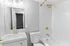 Modern bathroom with sleek fixtures, white tile backsplash, and stylish gold accents.