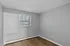 Bright room with a window and light gray walls, featuring smooth wooden floors.