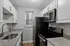 Chic kitchen with sleek black appliances, granite countertops, and pristine white cabinetry.
