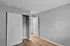 Bright and spacious minimalist bedroom with hardwood floors and built-in closet.