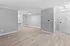 Bright modern open-concept living area featuring sleek wooden flooring and neutral gray walls.