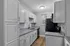 Contemporary kitchen with sleek white cabinetry, granite countertops, and stainless steel appliances.