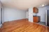 Bright apartment with hardwood floors and compact modern kitchen.