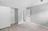 Modern bedroom with light wood flooring, white walls, and open closet space.