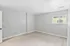 A bright and spacious room with neutral walls and a large window.