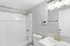 Contemporary bathroom with elegant gold fixtures, a spacious mirror, and a pristine white bathtub.