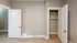 Bright room with beige walls featuring an open closet and wooden flooring.