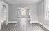 Bright and open living area with sleek gray flooring and ample natural light.