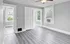 Bright, modern room with sleek flooring and large windows allowing natural light.