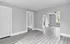 Open living space with modern gray flooring and large windows letting in natural light.