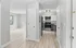 Bright and modern apartment featuring a sleek kitchen with stainless steel appliances and an open living space with light hardwood flooring.