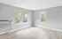 Sunlit modern room featuring large windows and sleek wooden flooring.
