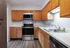 Modern kitchen featuring stainless steel appliances, wooden cabinetry, and marble countertops.