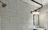 Elegant bathroom with marble-tiled walls, sleek vanity, and modern fixtures.