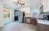 Bright modern kitchen with stainless steel appliances, white cabinets, and hardwood floors.